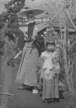 写真10　一千年祭の行列の衣装を着て近所の少女と。後ろに見えるのは開運橋。